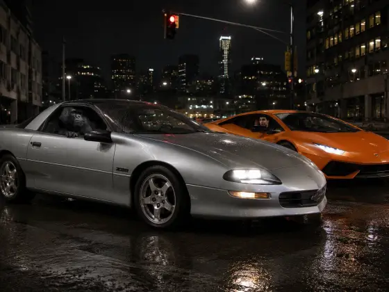 The Camaro next to an orange Lamborghini at night